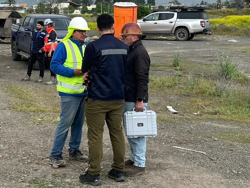 Asesores técnicos de Ulmen conversando en terreno, uno con un maletín de ensayo